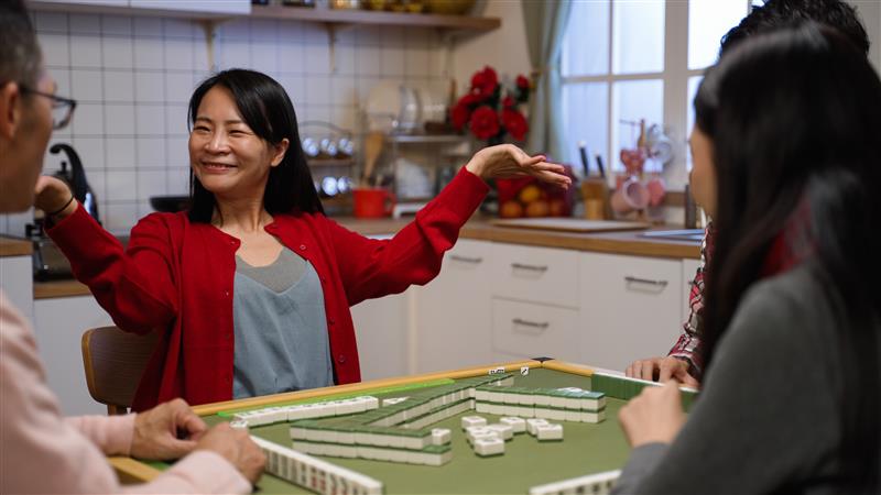 Family playing Dominoes game at kitchen table