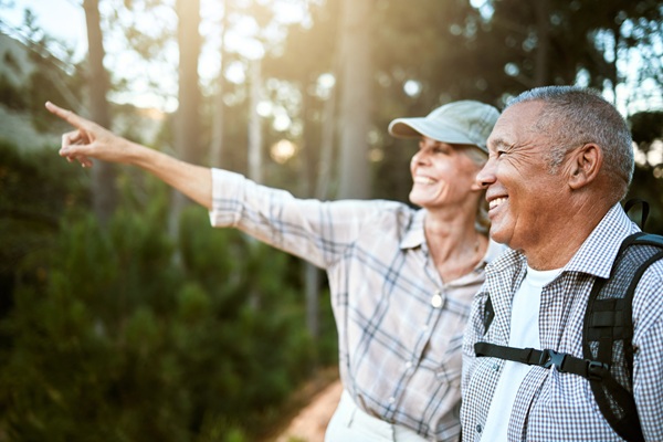 Couple hiking in the forest, woman pointing at something in the distance