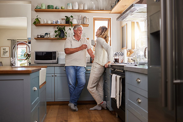 A couple in their kitchen drinking coffee together
