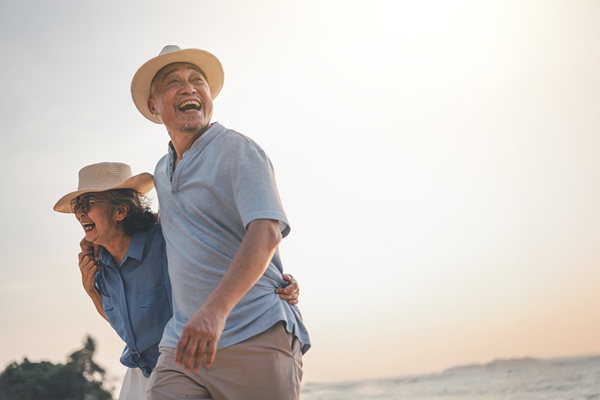 A couple walking together and laughing on a beach