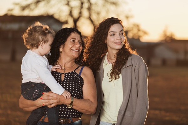 Three generations watch a sunset together